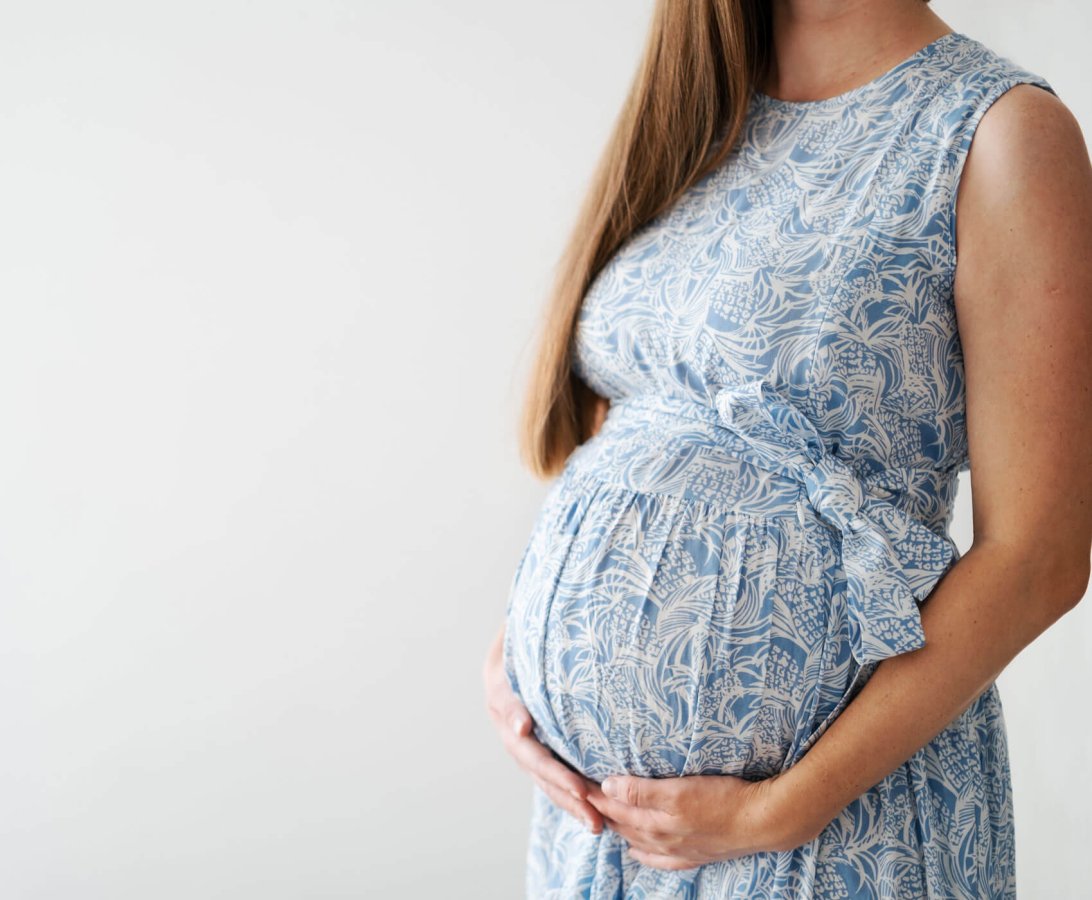 unrecognizable-pregnant-woman-caressing-belly-baby-bumpwearing-beautiful-blue-dressclothes-light-grey-backgroundhappy-healthy-stylishfashion-pregnancy