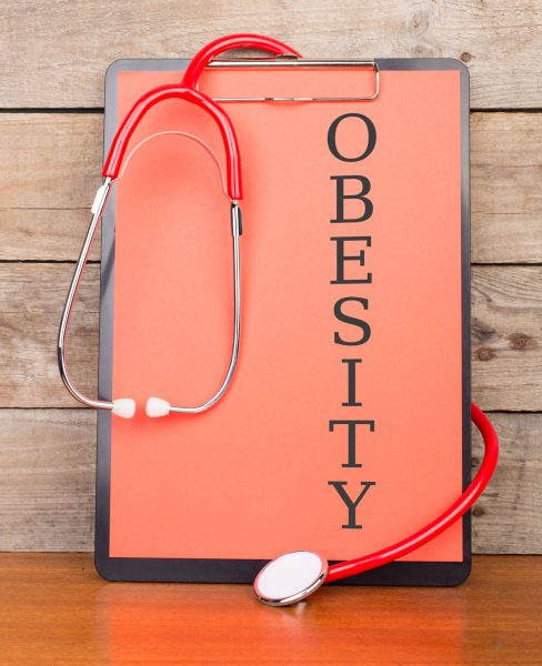 clipboard-with-word-obesity-stethoscope-wooden-background